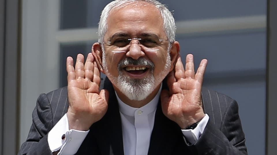 Der iranische Aussenminister Zarif freut sich und gestikuliert mit Journalisten.