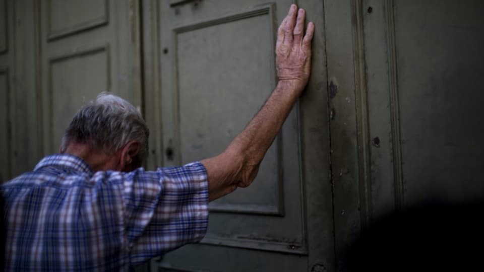 Ein griechischer Rentner vor dem geschlossenen Tor einer Bank in Athen.