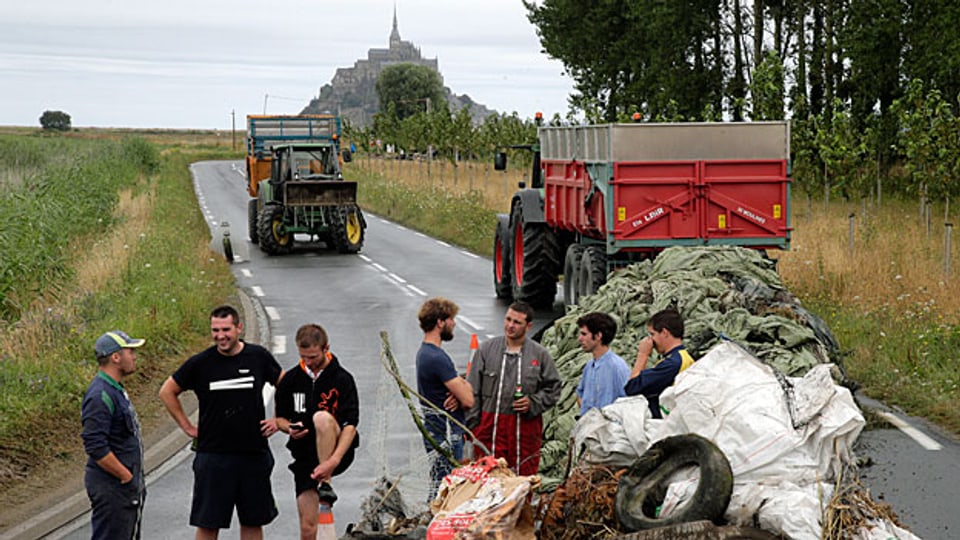 Vor der Welterbe-Kulisse Mont-Saint-Michel. Junge Bauern blockieren die Zufahrtsstrasse.