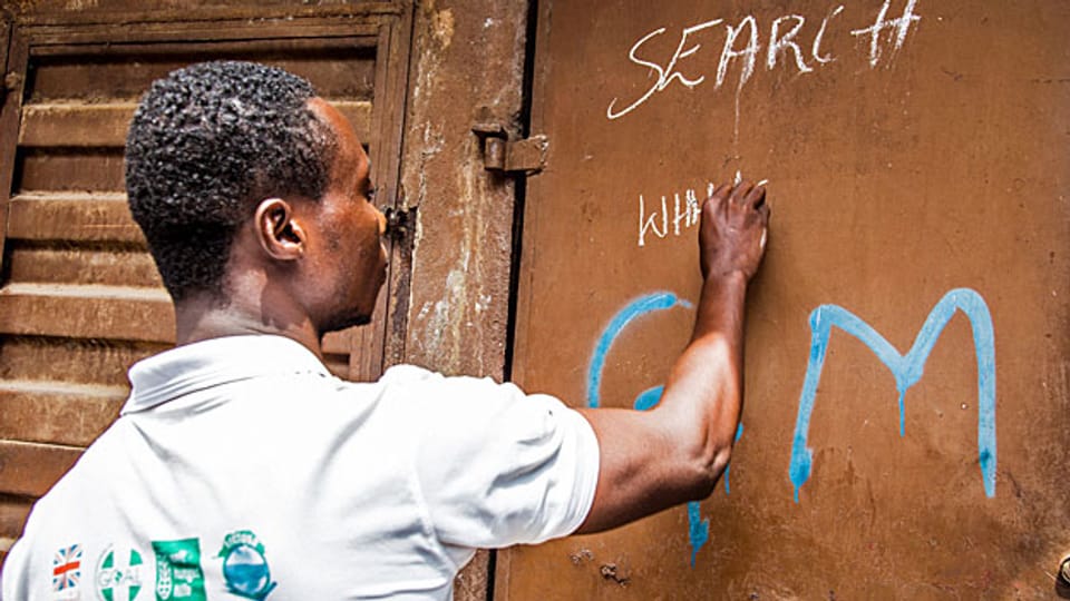 Einer der freiwilligen Gesundheitsarbeiter markiert in der Hauptstadt von Sierra Leone nach einem Kontrollbesuch, dass das Haus «sauber» ist; er hat keine Ebola-Kranken angetroffen.