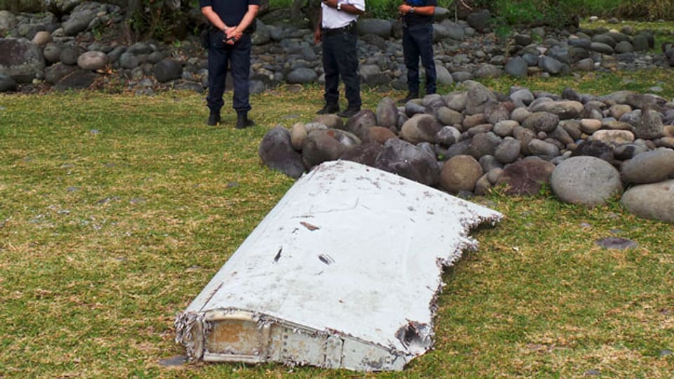 Französische Polizisten bewachen das auf La Réunion gefundene Wrackteil. Noch ist unklar, ob es zur verschwundenen Malaysia Airlines Flug MH370 gehört.