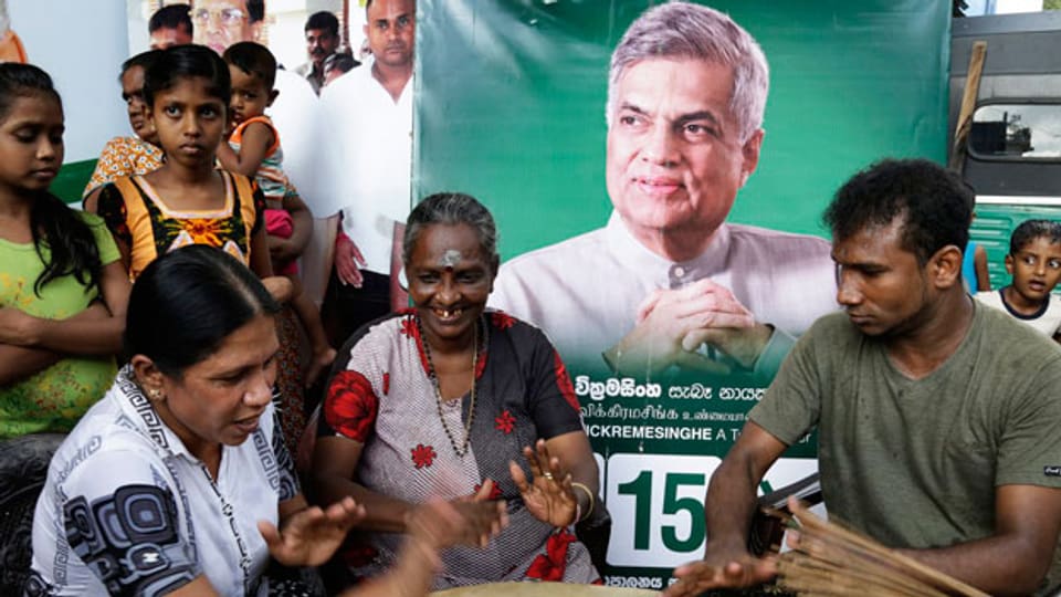 Unterstützer feiern eine mögliche Bildung einer neuen Regierung vor einem Poster des Parteichefs und ehemaligen Ministerpräsidenten Ranil Wickramasinghe.