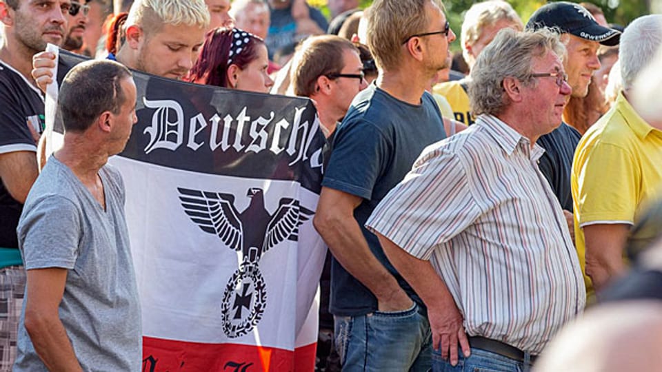 Etwa 1000 Leute protestieren im ostdeutschen Heidenau gegen eine Asylunterkunft für 250 Flüchtlinge. Einer von ihnen trägt eine Fahne mit dem Reichsadler und dem Satz «Deutschland – meine Heimat».