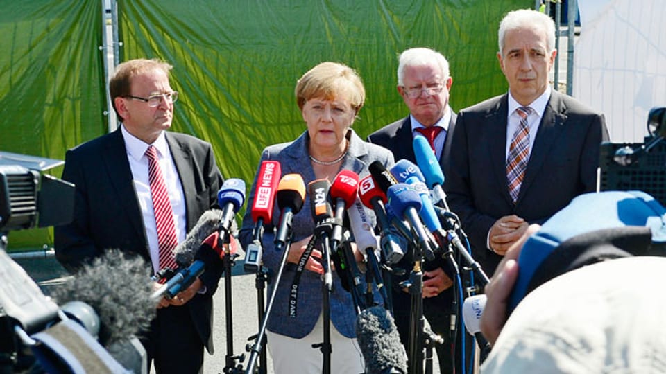Die deutsche Bundekanzlerin Angela Merkel kündigt bei einem Besuch im Flüchtlingszentrum Heidenau Gesetzesänderungen an.