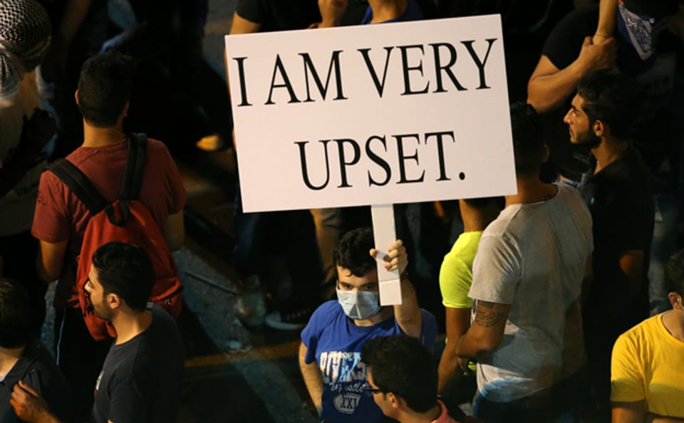 Ein Demonstrant drückt seinen Unmut über die Unfähigkeit der Regierung mit einem Protest-Schild aus