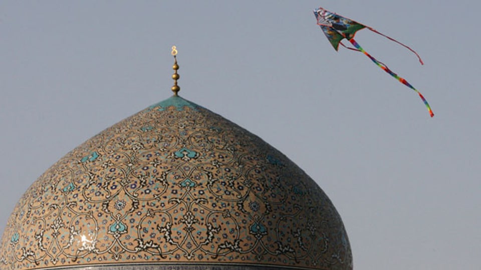 Symbolbild. Ein Drache fliegt über die Kuppel einer Moschee in Isfahan, Iran.