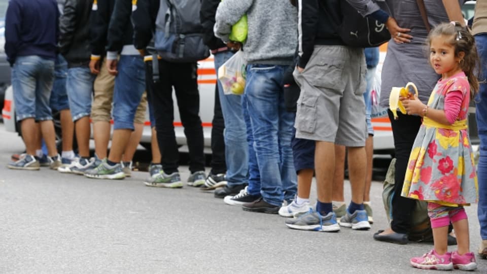 Flüchtlinge warten ausserhalb des Bahnhofs München auf ihre Weiterreise.