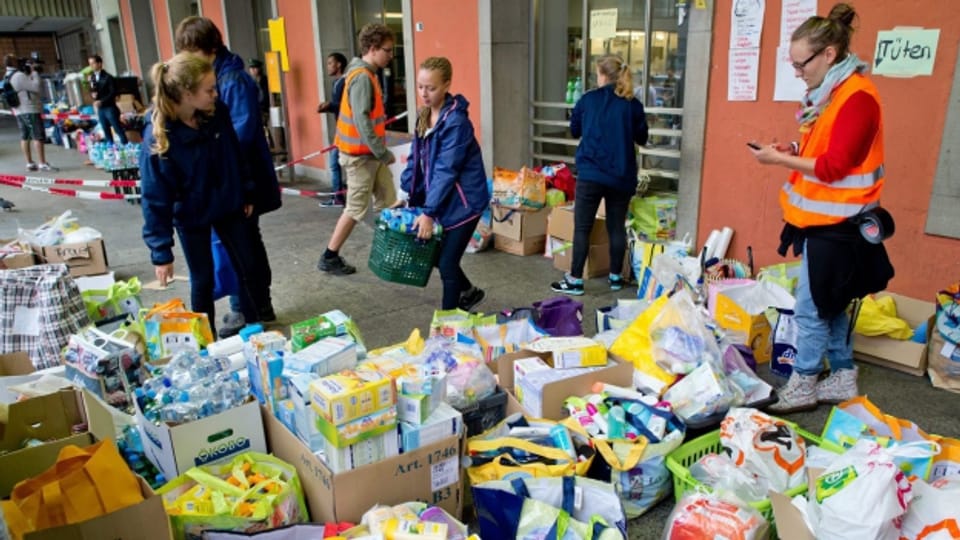 Helferinnen und Helfer sortieren am Hauptbahnhof München Hilfsgüter für angekommene Flüchtlinge.