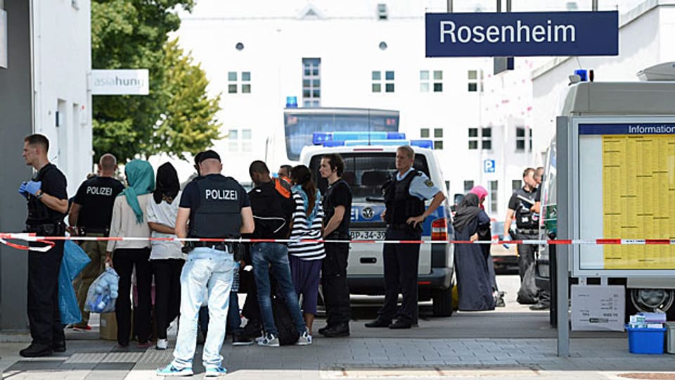 In Rosenheim, südlich von München, steht eine Gruppe von Flüchtlingen  Schlage, sie werden registriert.