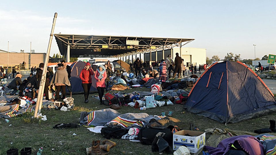Neben Polizeibeamten will die österreichische Regierung auch die Armee einsetzen. Die rund 2000 Soldaten sollen vor allem humanitäre Hilfe leisten, aber auch die Polizei an der Grenze unterstützen. Bild: Flüchtlinge an der ungarisch-österreichischen Grenze, am Montagmorgen.