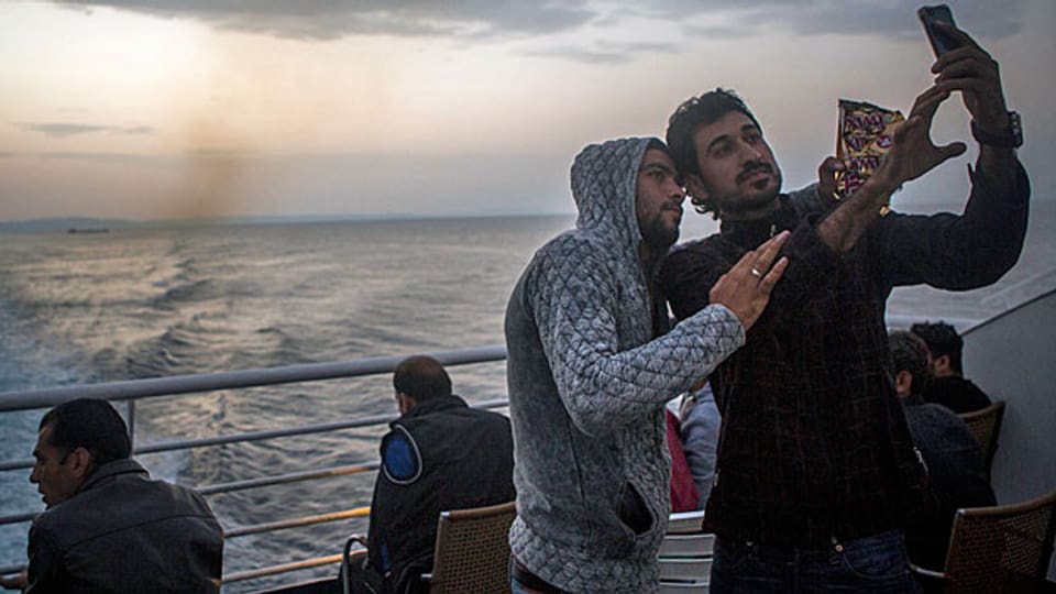 Filmen an Bord einer Fähre, die Flüchtlinge von der griecheischen Insel Lesbos in den Hafen von Piräus bringt.