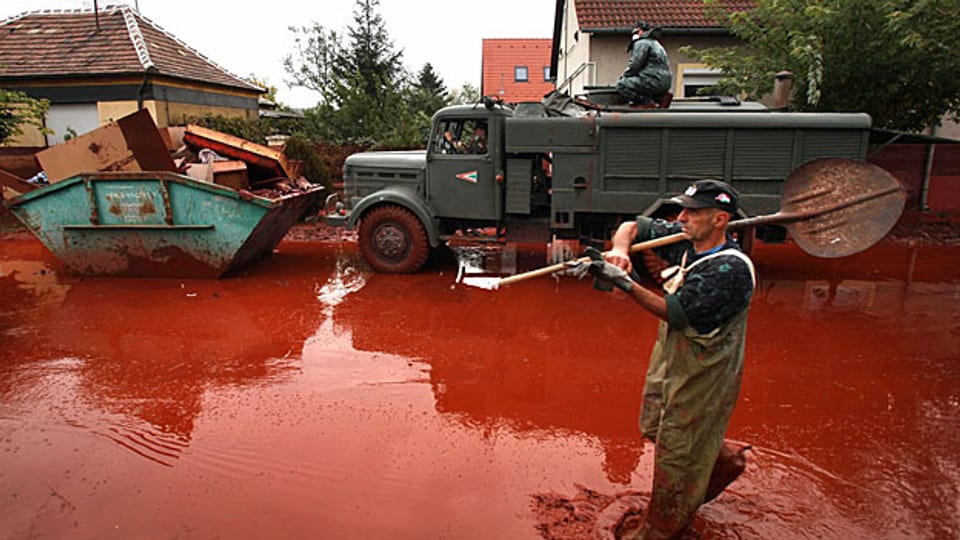 Über eine Million Kunikmeter des roten Schlamms haben Anfang Oktober 2010 das Dorf Devecser überschwemmt. Bild: Freiwilliger Helfer bei den Aufräumarbeiten.