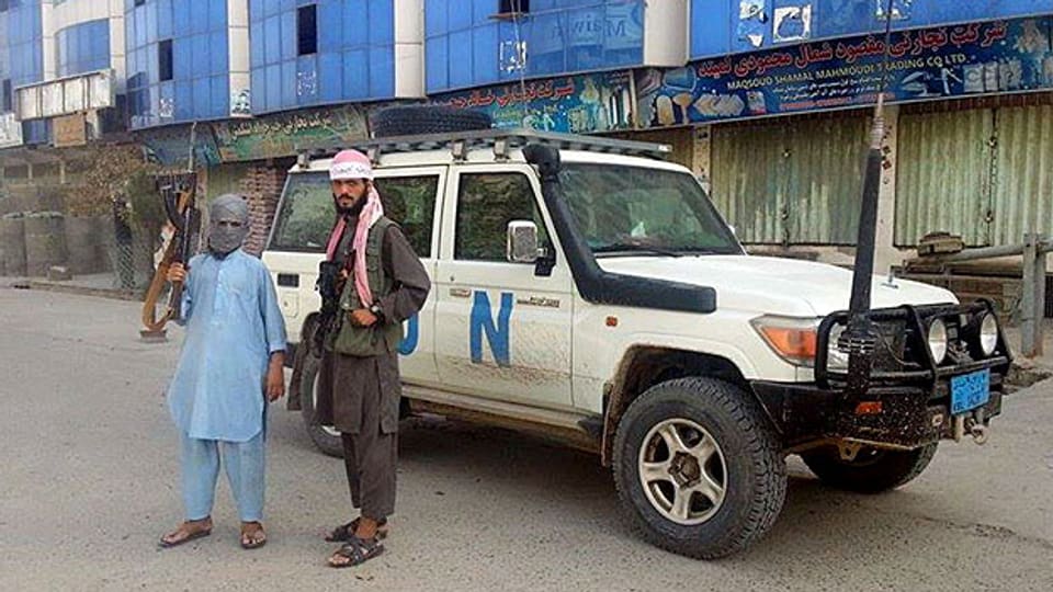 Erstmals seit 14 Jahren haben die islamistischen Taliban eine afghanische Provinzhauptstadt erobert – zwei Taliban-Kämpfer posieren in Kundus vor einem Auto der UN-Truppen.