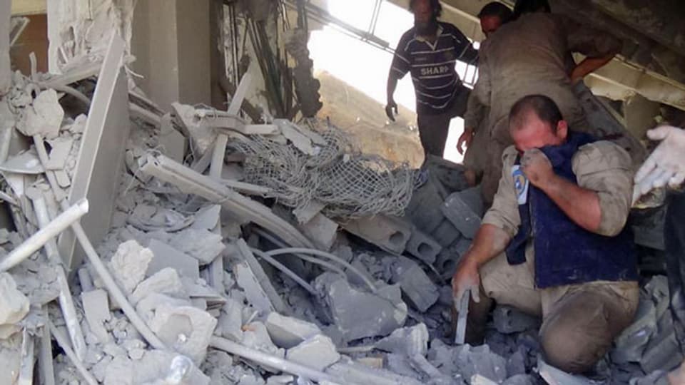 Zivilisten betrachten die Zerstörung, die der russische Luftangriff im Norden von Syrien verursacht hat.