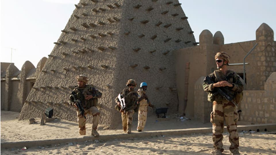 Französische Soldaten bewachen den Eingang der Sankoré-Moschee in Timbuktu. Sie stammt aus dem 14. Jahrhundert. Mit Hilfe der UNESCO wurde ein Programm zur Konservierung aufgelegt. Drei weitere Moscheen aus dieser Zeit, die El-Hena-Moschee, die Kalidi-Moschee und die Algourdour-Djingareye-Moschee, sind zerstört.