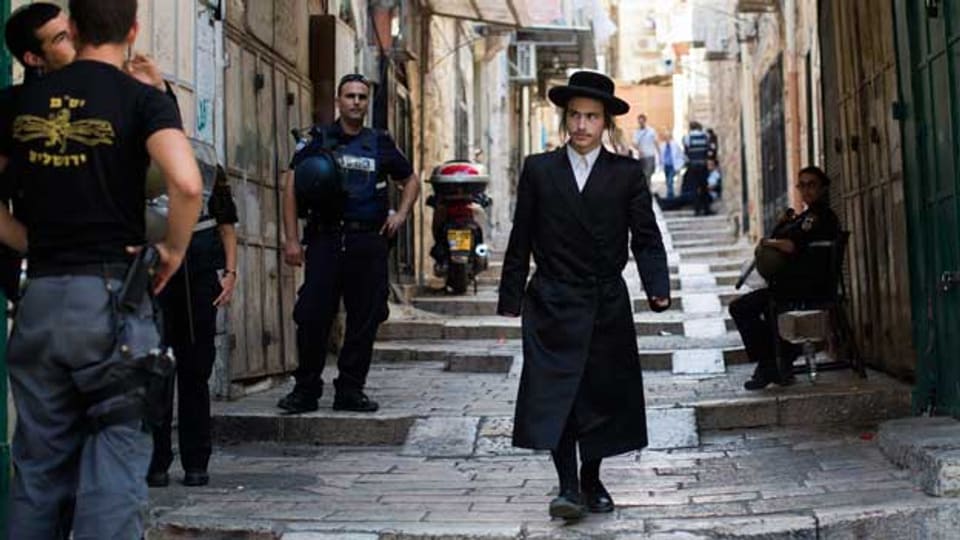 Ein orthodoxer Jude läuft durch die Altstadt von Jerusalem. Den Palästinenser ist der Zutritt verboten.