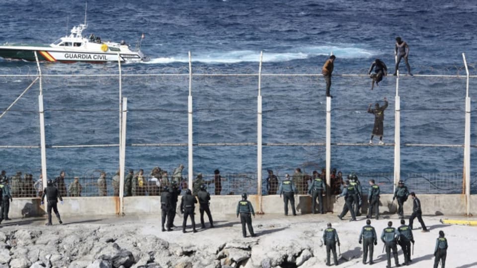 Flüchtlinge versuchen über den Grenzzaun in Ceuta zu kommen (August 2015).