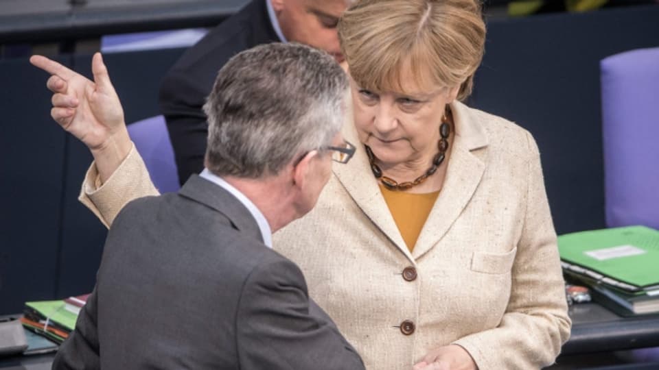 Kanzlerin Merkel spricht mit Innenminister de Maizière im deutschen Bundestag (1. Oktober 2015).