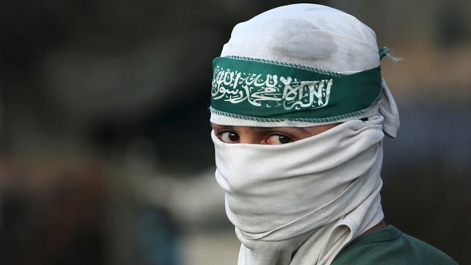 Ein maskierter palästinensischer Demonstrant während der Zusammenstösse mit israelischen Truppen in Jerusalem.