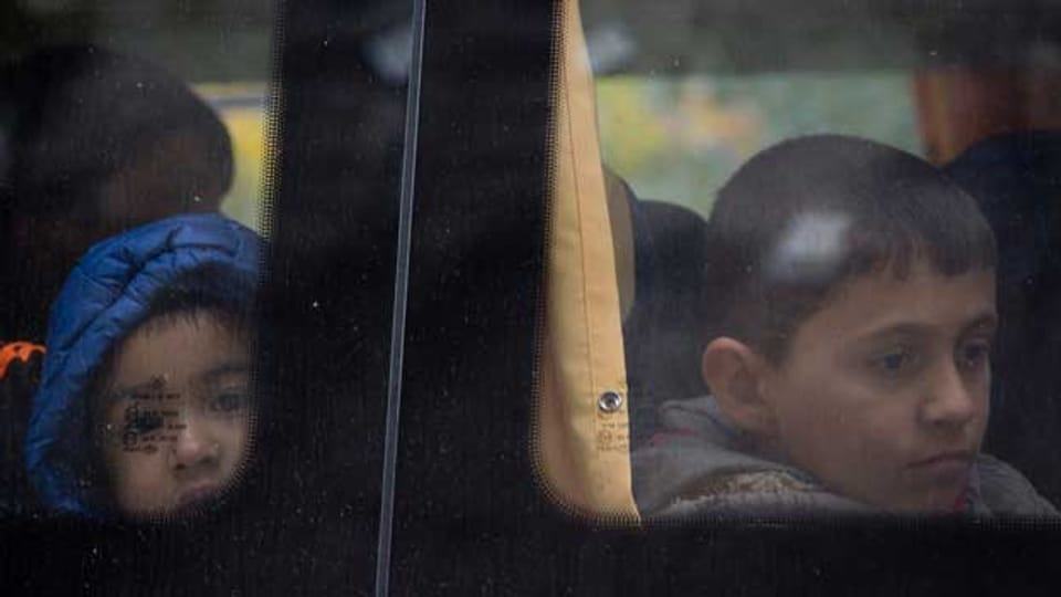 Kinder warten an der kroatisch-slowenischen Grenze - der Bus soll sie nach Österreich bringen.