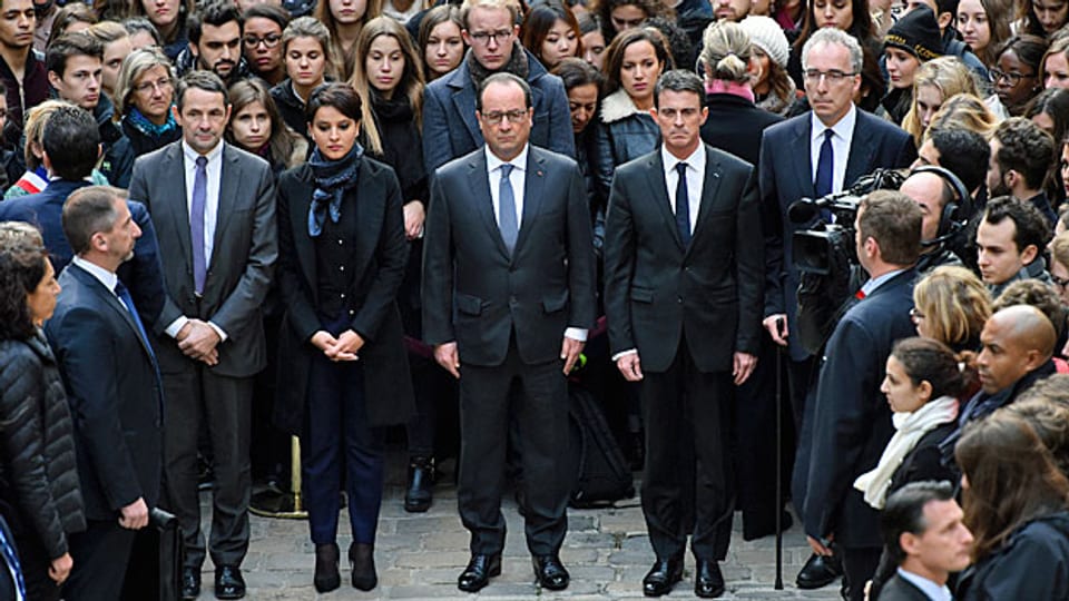 François Hollande und weitere Mitglieder der französischen Regierung haben sich zu einer Schweigeminute versammelt,