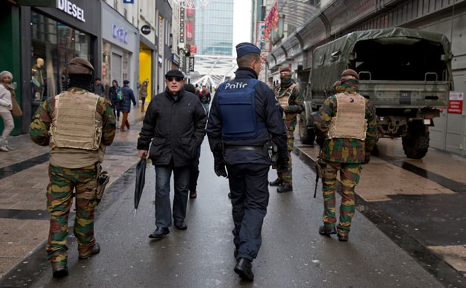 Polizisten und Soldaten patroullieren in einer sonst belebten Einkaufsstrasse in Brüssel
