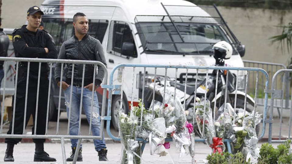 Ein tunesischer Polizist steht Wache in der Nähe des Ortes des Selbstmordanschlags in Tunis. Die Terrormiliz IS bekennt sich zum Anschlag