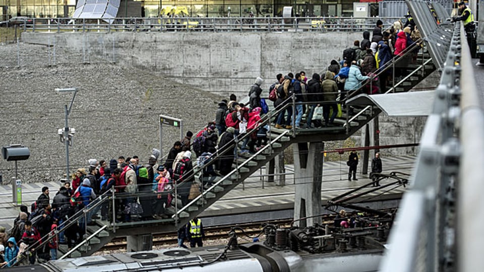 Noch vor einem Monat hat die schwedische Regierung betont, es würden keine Grenzen dichtgemacht oder Zäune gebaut. Nun geschieht es doch. Bild: Flüchtlinge, die von Dänemark mit dem Zug einreisen, werden in einem Bahnhof im schwedischen Malmö von Sicherheitskräften zur Ausweiskontrolle geleitet.