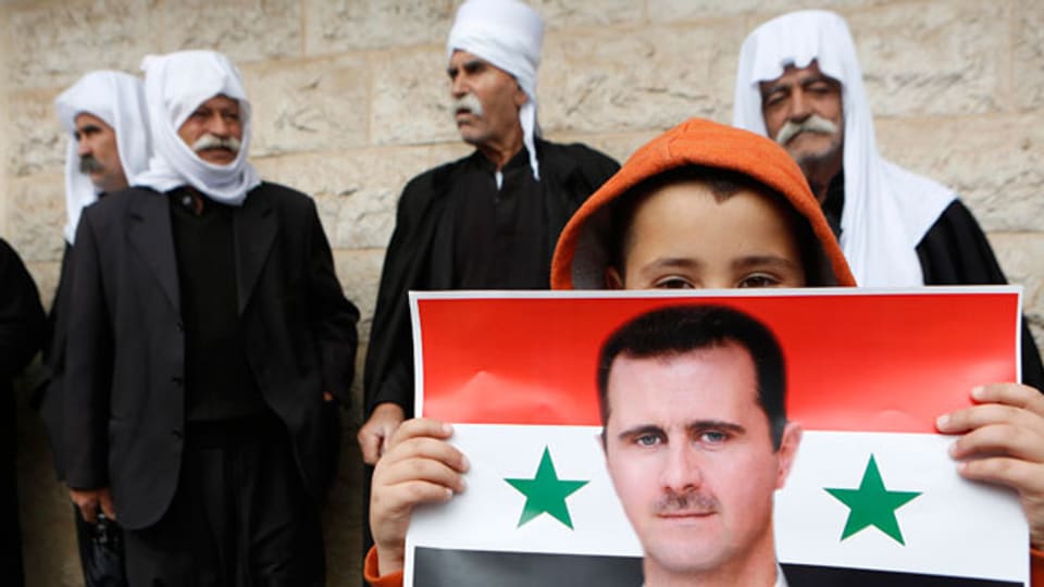 Die Drusen befürchten, dass sich Präsident Bashar al-Assads aus dem Drusengebiet zurückziehen wird. Ein Drusen- Junge hält eine syrische Fahne mit dem Bild von Syriens Präsident Bashar al-Assad.