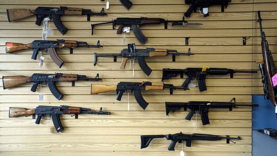 Im Schaufenster eines Waffengeschäfts sind halbautomatische und automatische Waffen ausgestellt.