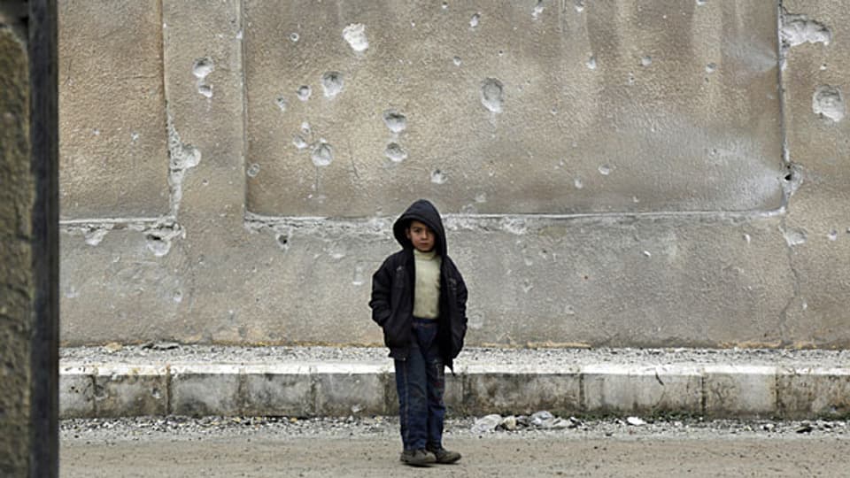 «Weiterarbeiten für die Menschen, die noch am Leben sind», sagt Azad. Symbolbild: Ein syrischer Junge steht vor einer zerbombten Schule.