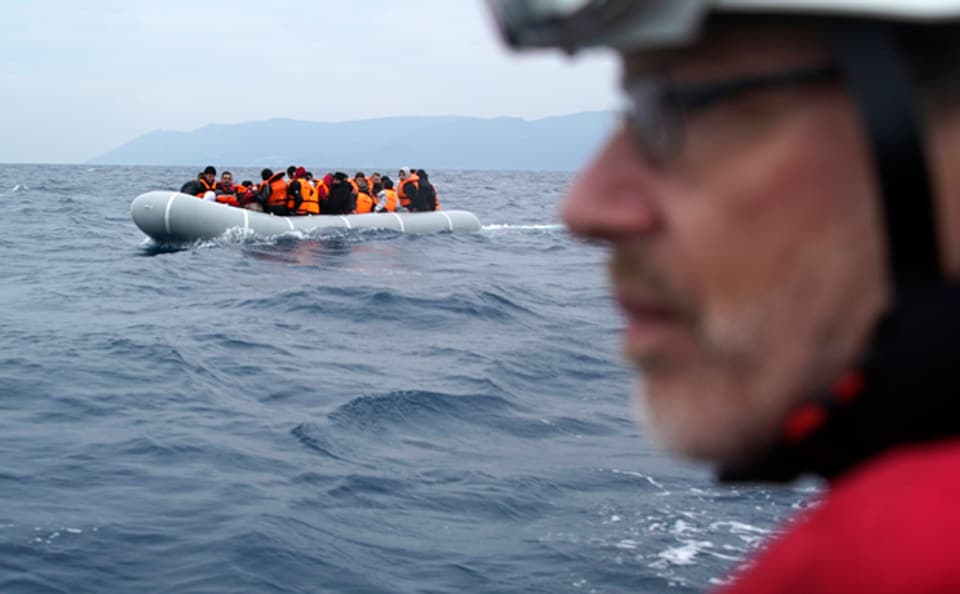 ein Freiwilliger beobachtet ein Flüchtlingsboot vor der Küste von Lesbos