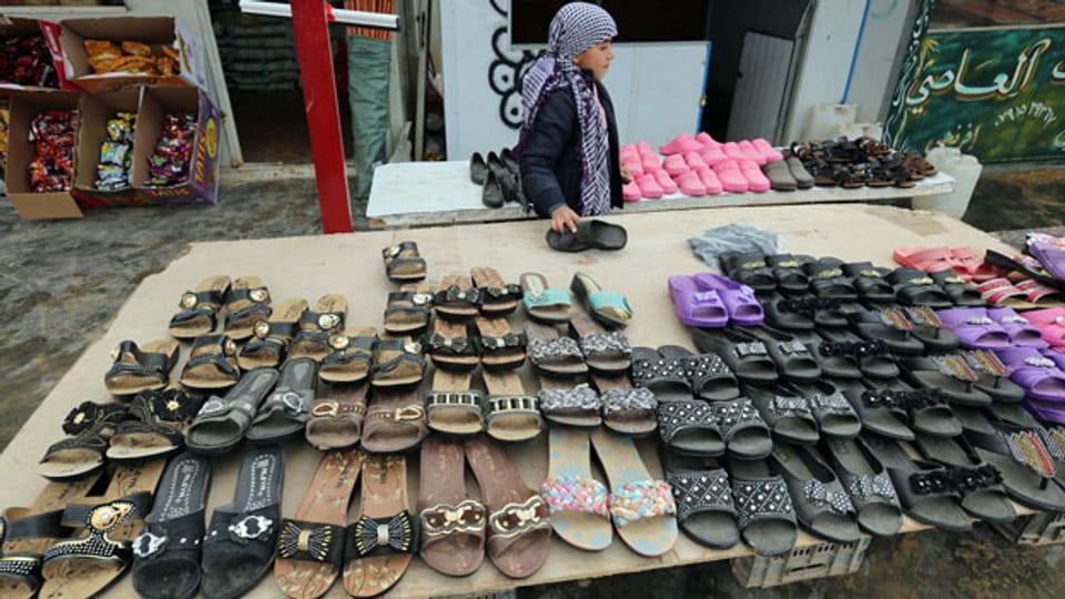 Ein Junge verkauft im Zaatari-Flüchtlingslager Jordanien Schuhe.