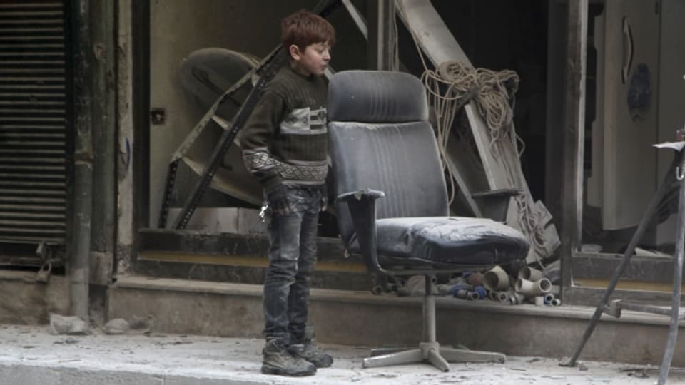 Eine Junge betrachtet die Schäden nach einem Luftschlag in Aleppo (4. Februar).