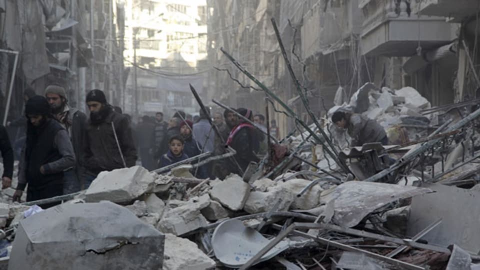 Die Bewohner der Stadt Al-Shaar in der Nähe von Aleppo betrachten die Schäden nach Luftangriffen durch pro-syrische Regierungstruppen.