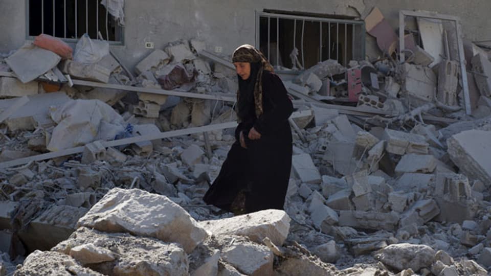 Eine Frau sucht sich ihren Weg durch die Trümmer der zerstörten Gebäude in der syrischen Stadt Dale am 12. Februar 2016.