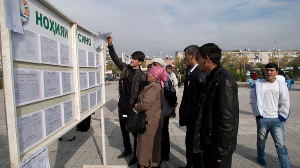 In Dushanbe stehen Arbeit suchende Leute vor einer Informationstafel, auf welcher freie Jobs angeboten werden.