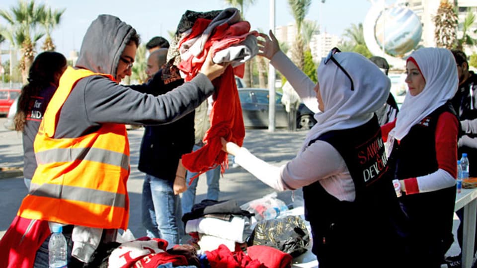 Freiwillige verteilen in den Strassen von Tripolis warme Winterkleider.