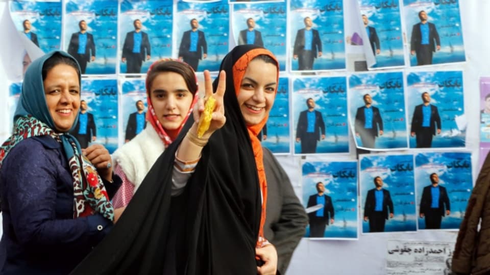 Eine Gruppe von Frauen posiert vor Wahlplakaten in Karaj.