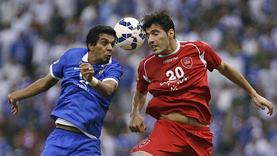 Die Fussballer Yousef al-Salem von Saudiarabien und Alireza Nourmohammadi von Iran. Gegeneinander spielen Ja, aber an einem neutralen Ort.