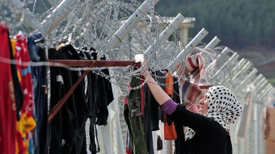 Eine syrische Flüchtlingsfrau hängt in einem Lager für syrische Flüchtlinge im Südosten der Türkei Kleidung auf. Die Europäische Union und die Türkei hoffen, in dieser Woche einer Lösung des Flüchtlingsproblems näher zu kommen.
