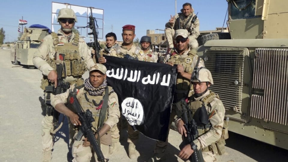 Irakische Soldaten präsentieren stolz eine eroberte Flagge des IS (30. März 2016).
