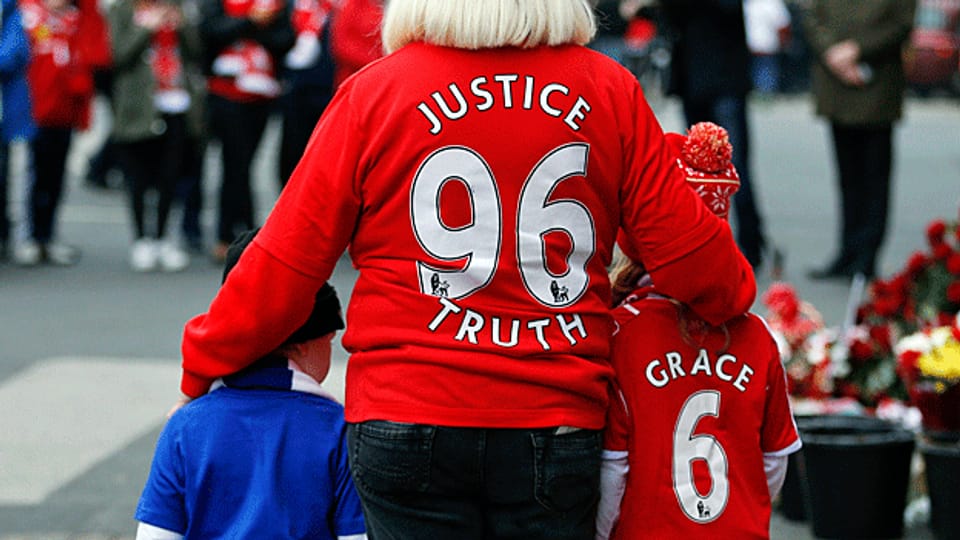 Eine Frau in einem Shirt des FC Liverpool, am 27. Gedenktag an die 96 Opfer von 1989. Nun hat ein Gericht die Ursache für die damalige Massenpanik teilweise der Polizei zugeschoben.