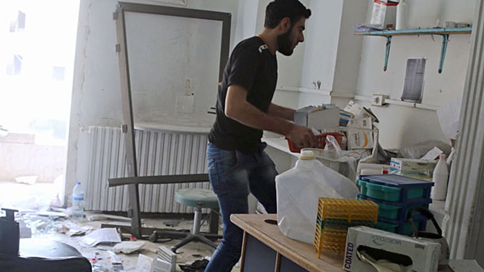 Ein Mann sammelt in einem zerbombten Raum im Spital von Mödecins sans Frontières in Aleppo Medikamente zusammen