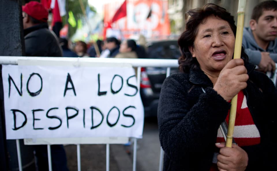 Eine Demonstrantin in Buenos Aires mit einem Schild: «keine Entlassungen mehr»