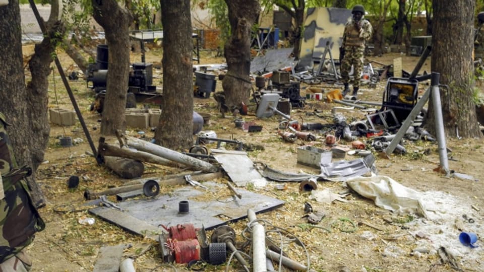 Ein nigerianischer Soldat begutachtet das Waffenarsenal in einem verlassenen Boko-Haram-Camp.