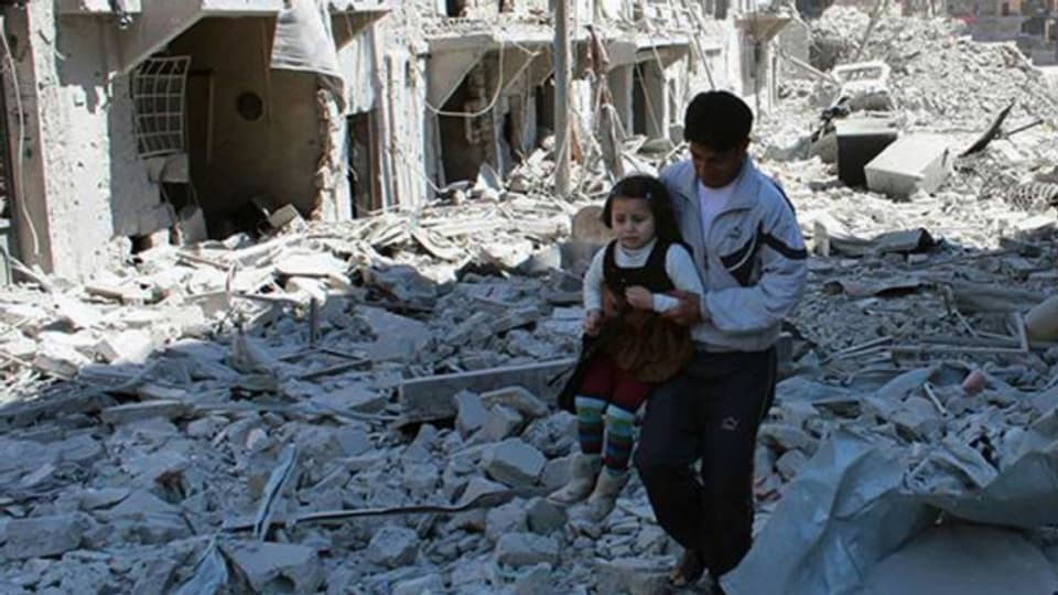 Der Krieg geht weiter: Ein Mann trägt ein kleines Mädchen durch die Trümmer von Aleppo (21. April 2014).