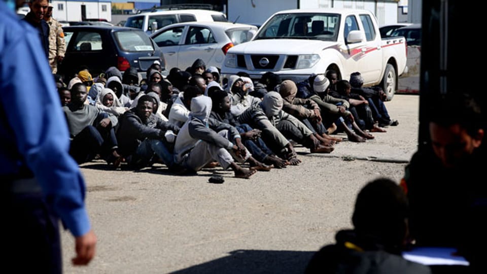 Afrikanische illegale Einwanderer warten in einem Hafen in Tripolis, Libyen, auf Hilfe, nachdem aus Seenot gerettet wurden.