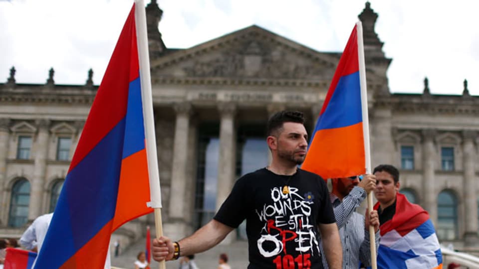 Ein Demonstrant mit armenischen Flaggen vor dem Reichstag, dem Sitz des Bundestags in Berlin.