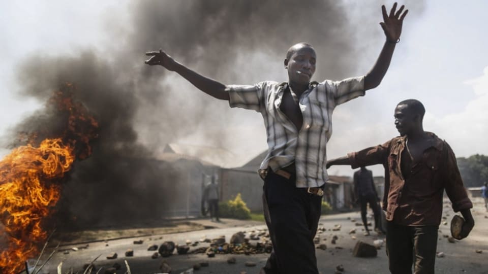 Zwei Demonstranten vor einem brennenden Auto in Burundis Hauptstadt Bujumbura (3. Juni 2015).